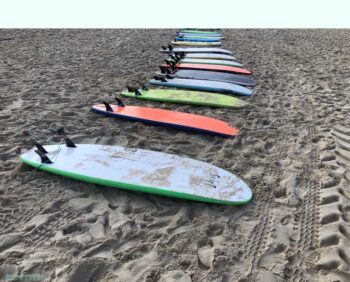 photograph 100X70 of colorful surfboards laying on the beach sand in Tel Aviv