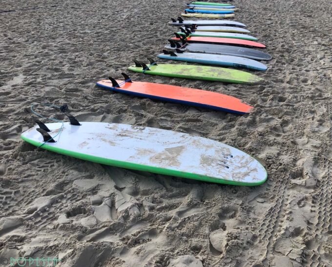 photograph of colorful surfboards laying on the beach sand in Tel Aviv